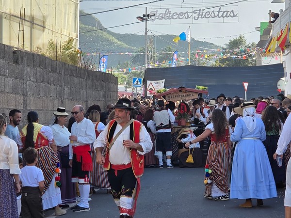 Romería de Tejina con gran afluencia de gente y participantes vestidos con trajes tradicionales canarios en una calle festiva.