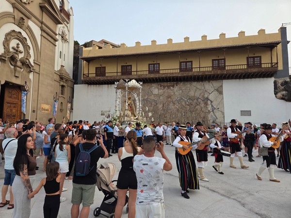 Procesión de la Virgen de Candelaria con músicos, asistentes y público reunido frente a la basílica durante una celebración religiosa.